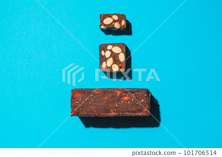 Raw pressed date with nuts and fruit bars isolated on blue background top view. Healthy gluten free snack for energy and diet 101706514