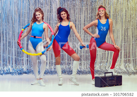 Beautiful young women in blue and red sportswear training fit fitness equipments, doing stretching and aerobics exercises Beautiful young women in blue and red sportswear training fit fitness equipments, doing stretching and aerobics exercises 101706582