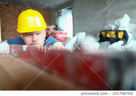 Bricklayer checks evenness of brick wall, brick foundation using spirit level Bricklayer checks evenness of brick wall, brick foundation using spirit level 101706768