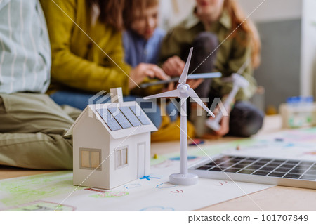 Close-up of house model with solar system and wind turbine during a school lesson. Close-up of house model with solar system and wind turbine during a school lesson. 101707849