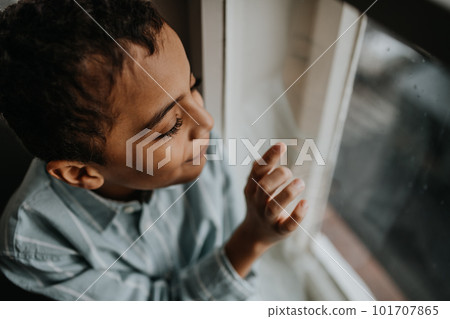 Little multiracial boy looking out of window. Little multiracial boy looking out of window. 101707865