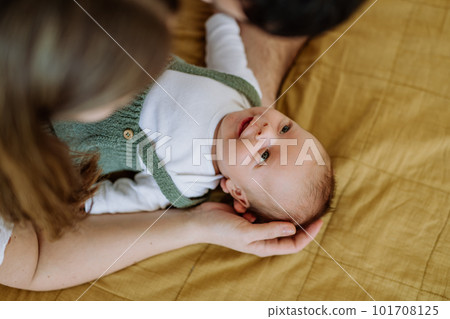 Happy parents cuddling with their newborn baby. 101708125