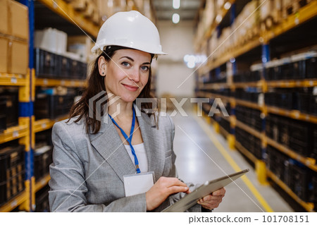 Manager woman in suit controlling goods in a waehouse. Manager woman in suit controlling goods in a waehouse. 101708151