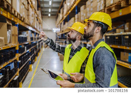 Warehouse workers checking stuff in warehouse with digital system in tablet. 101708156