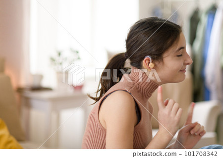 Portrait of teenage girl with hearing aid in her room. 101708342