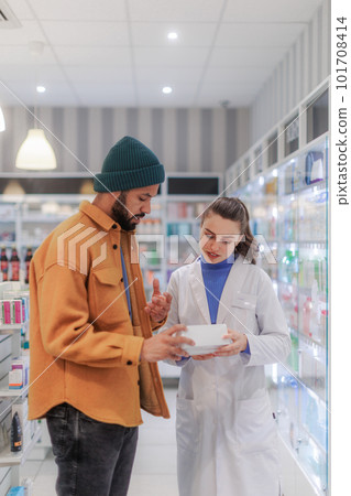 Young pharmacist helping customer to choos medication. 101708414