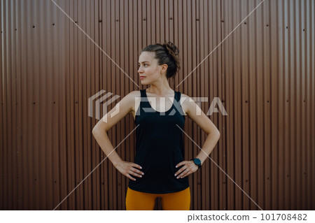 Portrait of young sportive woman outdoor in city. 101708482