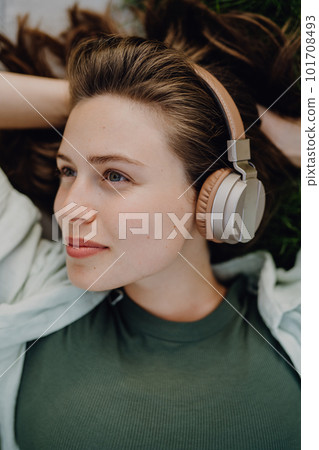 Portrait of young woman listening music trough headphones. Portrait of young woman listening music trough headphones. 101708493
