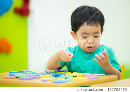 A boy playing with a toy 101709463