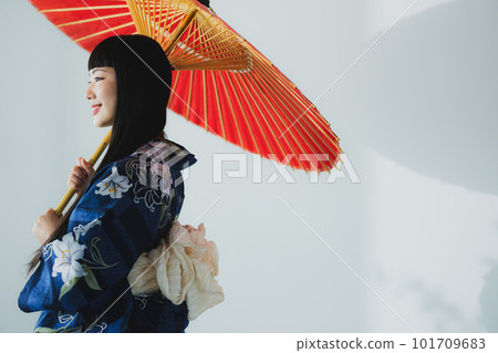 一個穿著浴衣的女人拿著一把日本傘 101709683