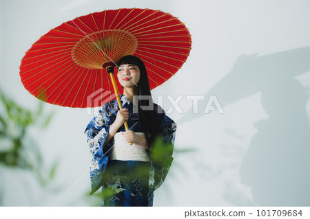 一個穿著浴衣的女人拿著一把日本傘 101709684