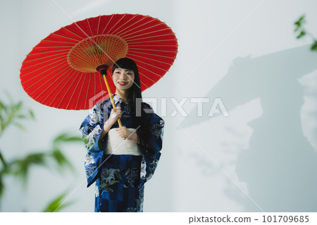 一個穿著浴衣的女人拿著一把日本傘 101709685