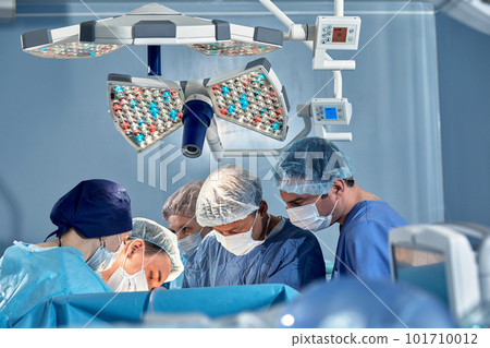 International team of surgeons in the operating room during the operation. Modern medicine, international medical workers during a complex operation, modern medicine. International team of surgeons in the operating room during the operation. Modern medicine, international medical workers during a complex operation, modern medicine. 101710012