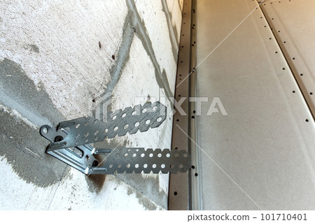 Unfinished brick wall in a room under construction prepared for drywall plates frame installation. 101710401