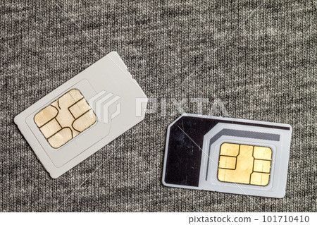 Two simcards isolated on grey cloth texture background Two simcards isolated on grey cloth texture background 101710410
