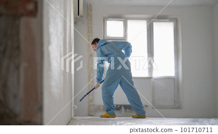 Man paints the ceiling with a roller 101710711