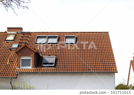 Roof of classic residential houses with orange roofing tiles and windows 101711015
