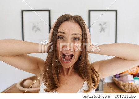 Portrait of young woman standing in light living room on daytime and expressing emotions. Shouting. Anger, shock, overworking Portrait of young woman standing in light living room on daytime and expressing emotions. Shouting. Anger, shock, overworking 101711190