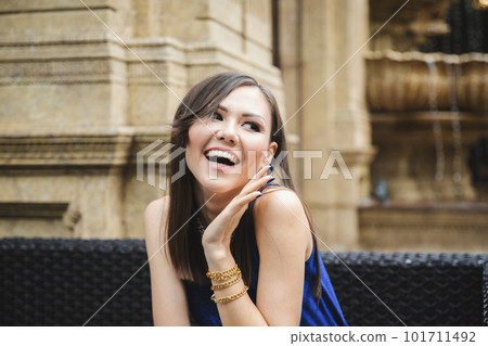 Pleasantly surprised young woman looking away while sitting in a street cafe Pleasantly surprised young woman looking away while sitting in a street cafe 101711492