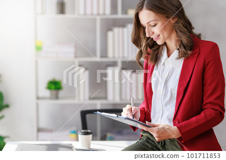 Concept of business investment or working woman,  Businesswoman wearing a suit sitting and working on analysis of business investment documents and using computer to analytic business data. 101711853