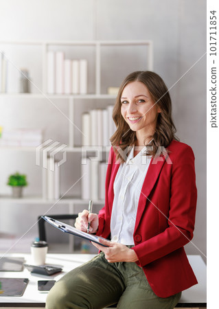 Concept of business investment or working woman, Businesswoman wearing a suit sitting and working on analysis of business investment documents and using computer to analytic business data. Concept of business investment or working woman, Businesswoman wearing a suit sitting and working on analysis of business investment documents and using computer to analytic business data. 101711854