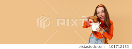 Banner with young adorable girl holding box with food and eating noodles with hunger face on ginger studio background. Junk, unhealthy food Banner with young adorable girl holding box with food and eating noodles with hunger face on ginger studio background. Junk, unhealthy food 101712183