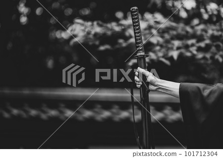 A person holding a Japanese sword 101712304