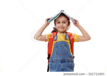 Caucasian smart student child girl,positive pleasant first grader holding open book above her head, smiling cutely looking at camera, isolated over white background. Back to school. Education concept Caucasian smart student child girl,positive pleasant first grader holding open book above her head, smiling cutely looking at camera, isolated over white background. Back to school. Education concept 101712903