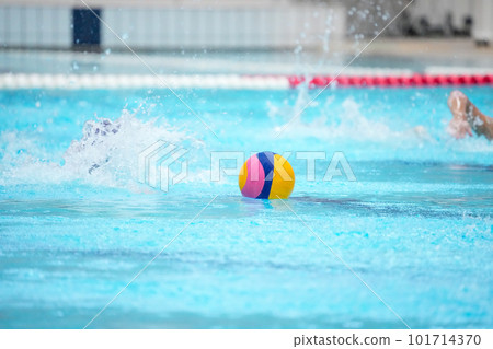 A player going to get the center ball floating in the center of the pool court immediately after the start of the water polo match A player going to get the center ball floating in the center of the pool court immediately after the start of the water polo match 101714370