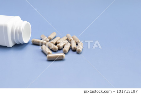 Scattered Pills, Capsules OF Slippery Elm, White Bottle, Container On Blue Background. Dietary Nutritional Supplement, Medication. Ulmus Fulva, Herbal Remedy Concept. Horizontal, Copy space For Text Scattered Pills, Capsules OF Slippery Elm, White Bottle, Container On Blue Background. Dietary Nutritional Supplement, Medication. Ulmus Fulva, Herbal Remedy Concept. Horizontal, Copy space For Text 101715197