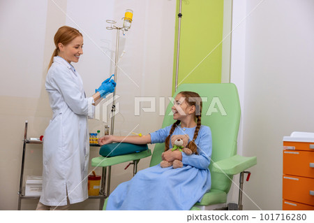 Little girl kid in clinic room having dropper with medication, doctor with drop counter and patient Little girl kid in clinic room having dropper with medication, doctor with drop counter and patient 101716280