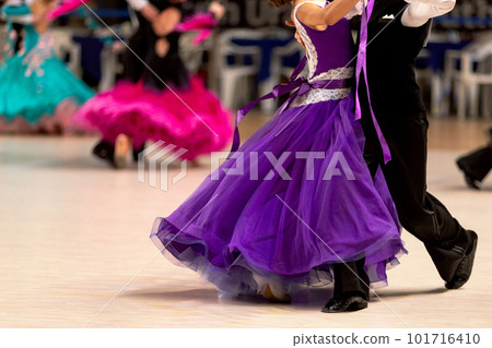 young couples dancers dancing waltz in dancesport competition, colorful dresses for girls and black tail suit for boys young couples dancers dancing waltz in dancesport competition, colorful dresses for girls and black tail suit for boys 101716410
