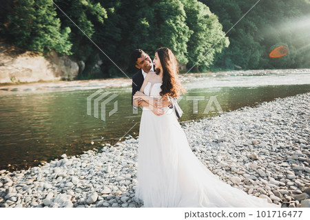 Wedding couple, groom and bride hugging, outdoor near river 101716477