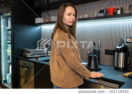 Tranquil barista posing for the camera in her working place Tranquil barista posing for the camera in her working place 101716492