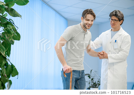 Nurse assisting a patient to walk with a stick Nurse assisting a patient to walk with a stick 101716523