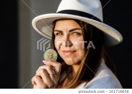 Closeup of hand holding golden bitcoin, copy space for cryptocurrency commercial, digital money, electronic investment. Cropped portrait of businesswoman holding bitcoin and showing it to the camera. 101716656