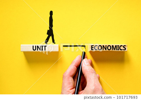 Unit economics symbol. Concept words Unit economics on wooden blocks. Beautiful yellow table yellow background. Businessman hand. Businesswoman icon. Business and unit economics concept. Copy space. Unit economics symbol. Concept words Unit economics on wooden blocks. Beautiful yellow table yellow background. Businessman hand. Businesswoman icon. Business and unit economics concept. Copy space. 101717693