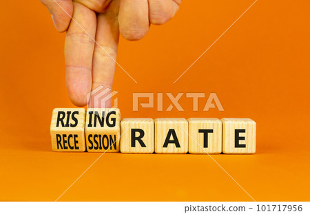 Recession or rising rate symbol. Concept word Recession rate Rising rate on wooden cubes. Businessman hand. Beautiful orange background. Business recession or rising rate concept. Copy space. Recession or rising rate symbol. Concept word Recession rate Rising rate on wooden cubes. Businessman hand. Beautiful orange background. Business recession or rising rate concept. Copy space. 101717956