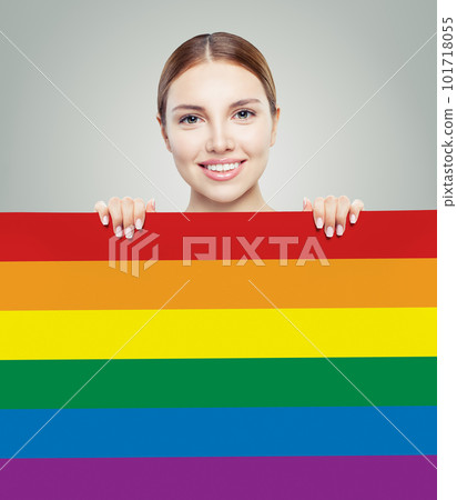 Cheerful young woman showing LGBT flag on gray background. Cheerful young woman showing LGBT flag on gray background. 101718055