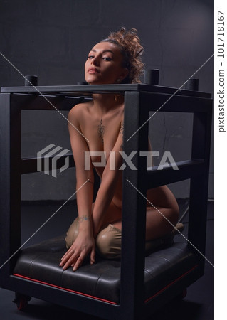 Seductive naked female in bondage cage in darkness Seductive naked female in bondage cage in darkness 101718167