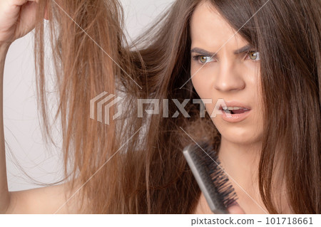 Young woman with comb worried about hair loss Young woman with comb worried about hair loss 101718661