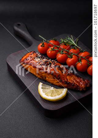 Delicious grilled red salmon fish with sauce, sesame seeds, spices and herbs Delicious grilled red salmon fish with sauce, sesame seeds, spices and herbs 101718697