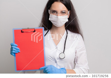 Female doctor holding a blank sheet of paper with space for text Female doctor holding a blank sheet of paper with space for text 101719256
