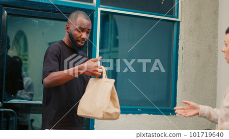 Customer receiving wrong food delivery order in paperbag, worker being confused about takeaway problem. Unsatisfied man rejecting fastfood package on fast forward. Timelapse. Handheld shot. 101719640