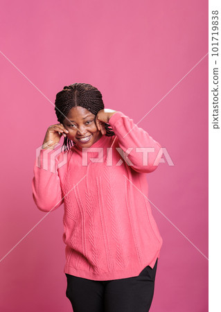 Young cheerful adult fooling around and being silly in studio, having fun in front of camera over background. Casual excited woman being positive and optimistic, enjoying laugh and smiling. Young cheerful adult fooling around and being silly in studio, having fun in front of camera over background. Casual excited woman being positive and optimistic, enjoying laugh and smiling. 101719838