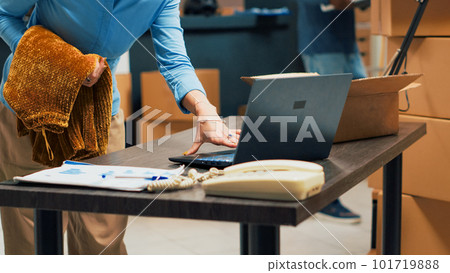 Caucasian woman preparing order shipment fom warehouse, putting products in cardboard boxes. Taking merchandise from storage shelves, working on distribution and logistics. Handheld shot. Caucasian woman preparing order shipment fom warehouse, putting products in cardboard boxes. Taking merchandise from storage shelves, working on distribution and logistics. Handheld shot. 101719888