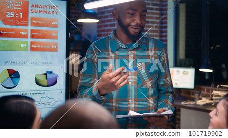 African american executive presenting company financial report, employee speaking in coworking space. Diverse coworkers in business meeting, revenue statistics presentation African american executive presenting company financial report, employee speaking in coworking space. Diverse coworkers in business meeting, revenue statistics presentation 101719902