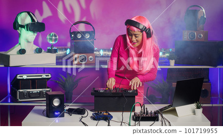 Cheerful dj mixing and mastering electronic sound using professional turntables, enjoying performing music during night party in club. Asian artist doing performance with audio equipment 101719955