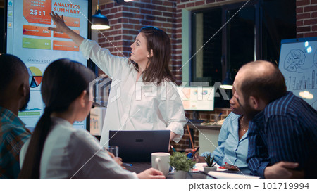 Employee speaking in business meeting presentation, holding laptop, financial analytics report. Team working on company research statistics, planning marketing strategy, discussing charts 101719994