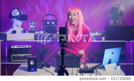 Performer recording music session with smartphone camera, mixing and mastering electronic sound preparing eletronic concert. Musician performing techno song using professional audio equipment Performer recording music session with smartphone camera, mixing and mastering electronic sound preparing eletronic concert. Musician performing techno song using professional audio equipment 101720086